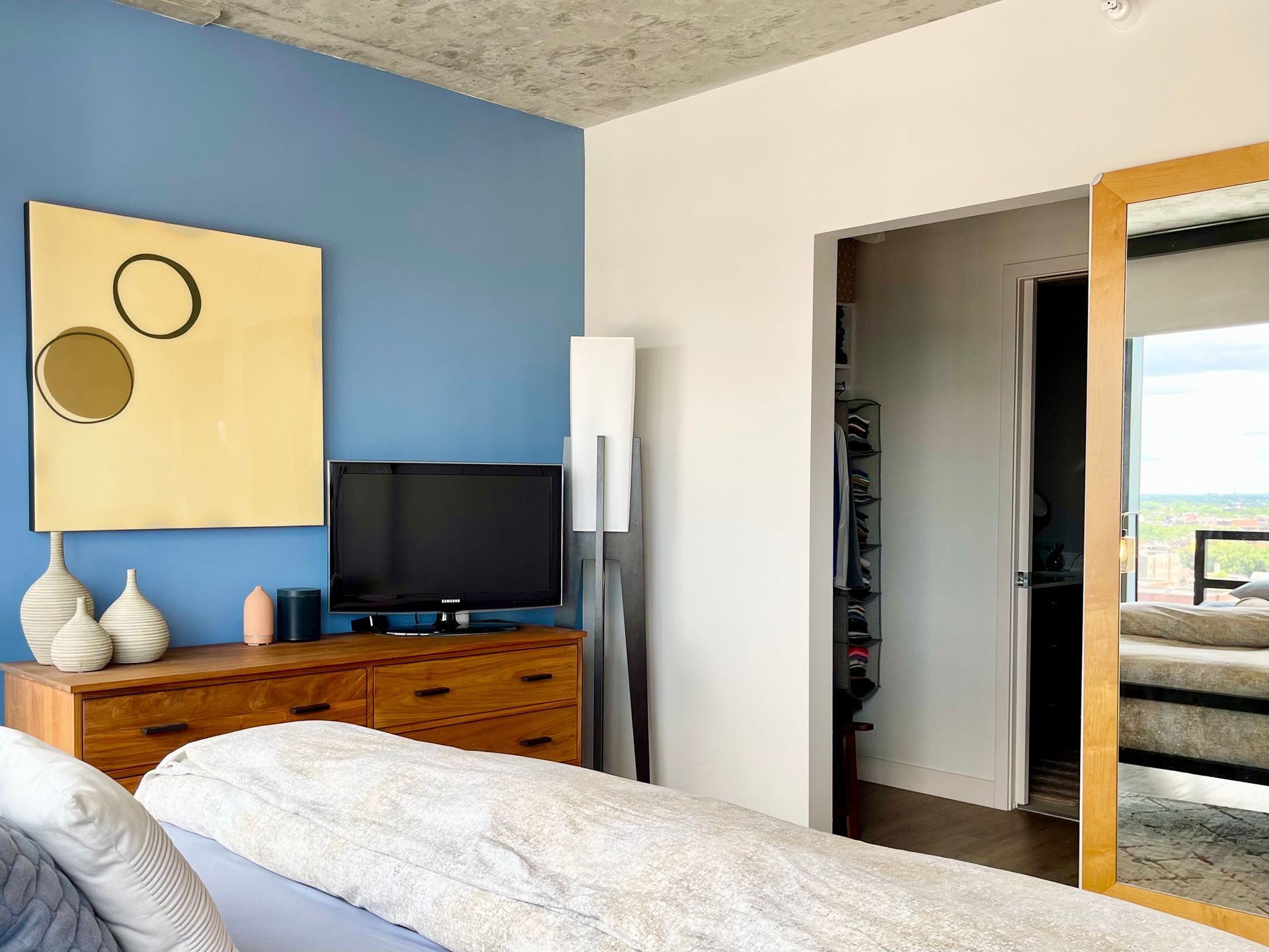 A bedroom with blue walls and a large mirror
