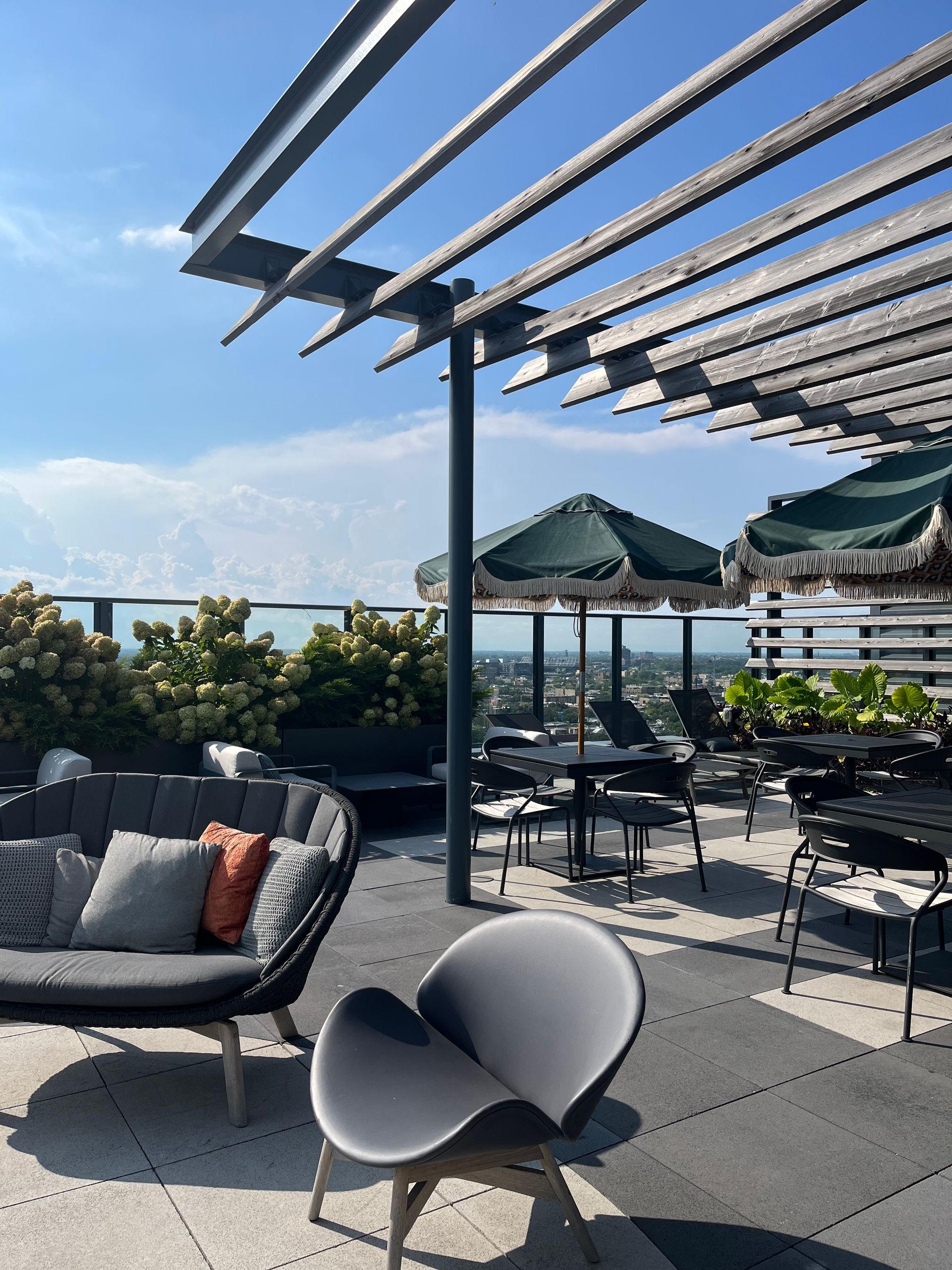 A patio with a couch and chairs under a pergola
