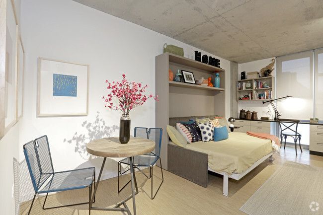 An artist 's impression of a bedroom with a bed , table and chairs.