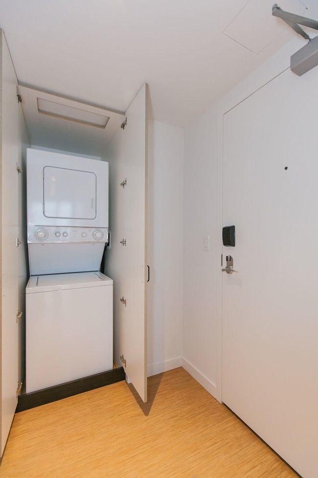 A washer and dryer are stacked on top of each other in a closet.