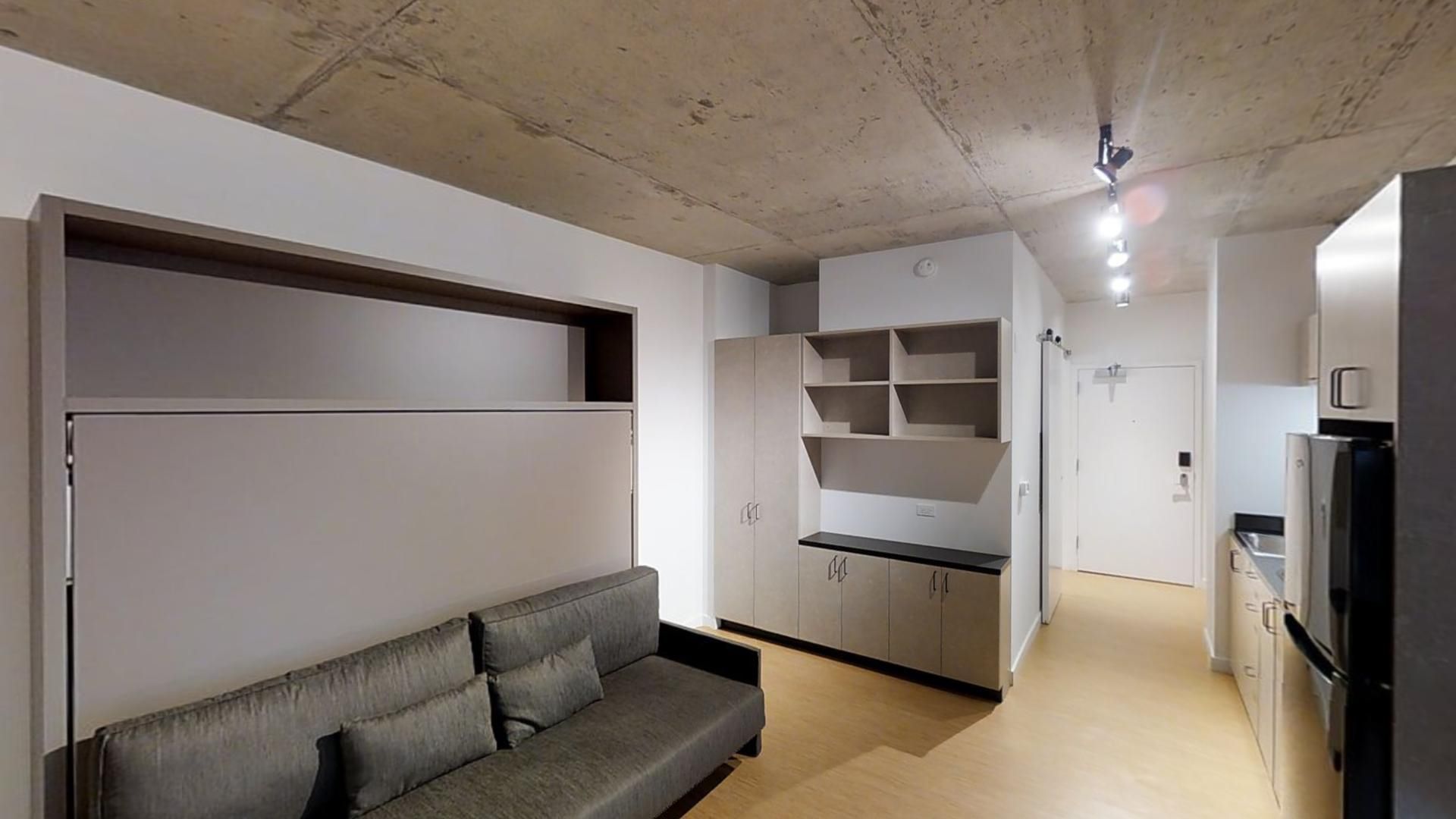A living room with a couch and a kitchen