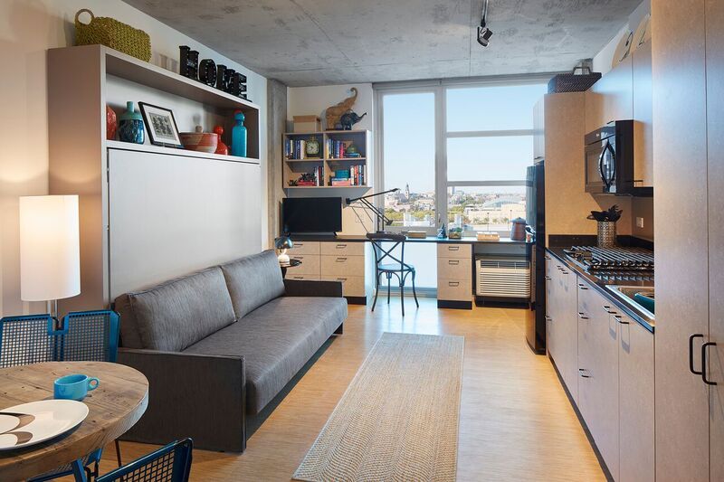 A living room with a couch and a kitchen