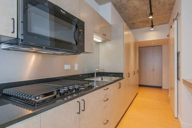 A kitchen with a stove , sink , and microwave.