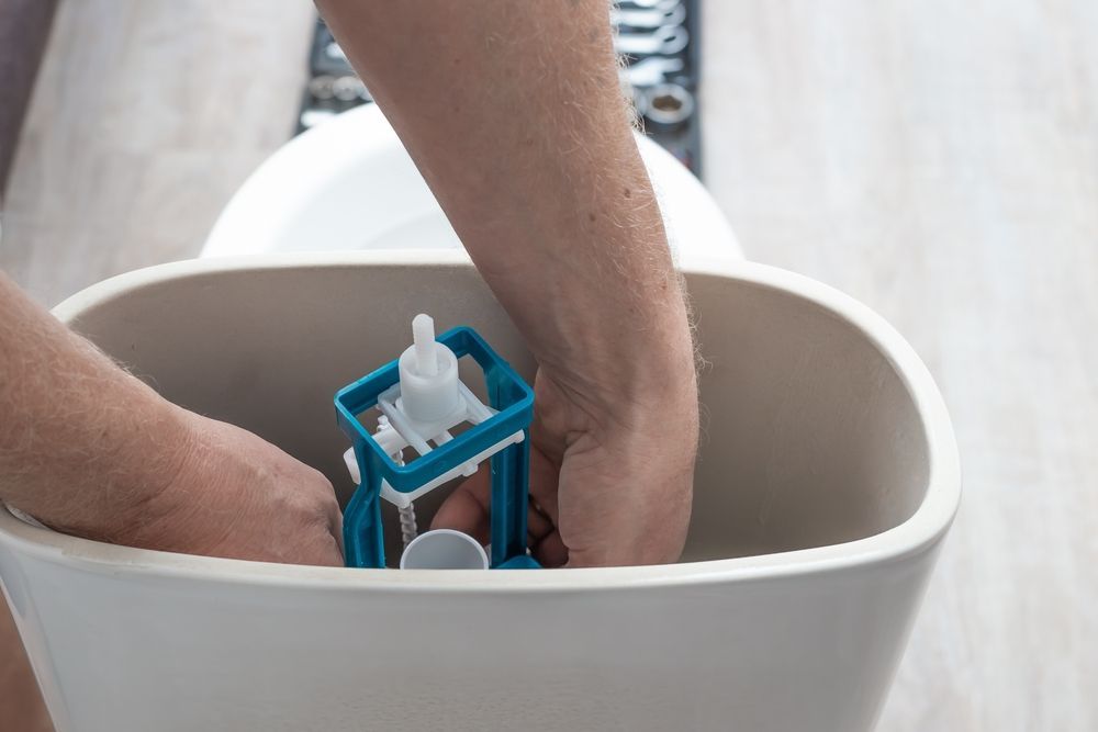 Person Repairing a Toilet Tank, Installing a Flush Valve — Full On Plumbing & Gas in Casuarina, NT
