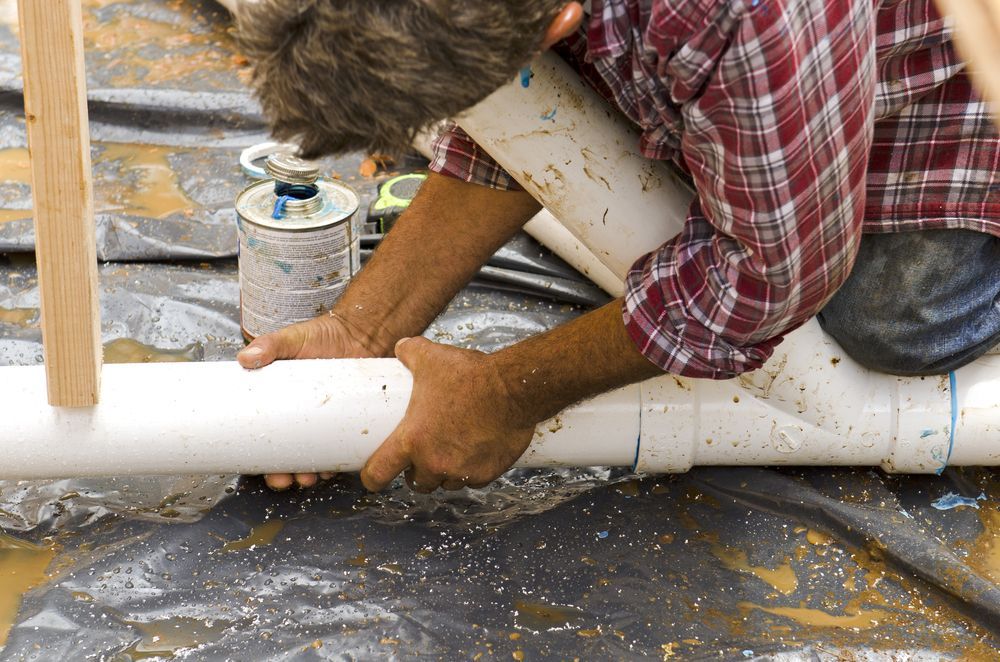 Person Connecting White Pvc Pipes, Using Glue, Outdoors — Full On Plumbing & Gas in Winnellie, NT