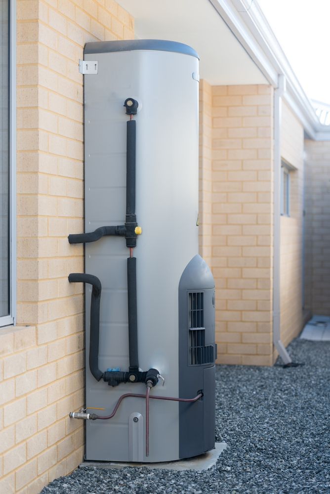 A Tall, Silver and Grey Water Heater Installed on a Beige Brick House — Full On Plumbing & Gas in Winnellie, NT
