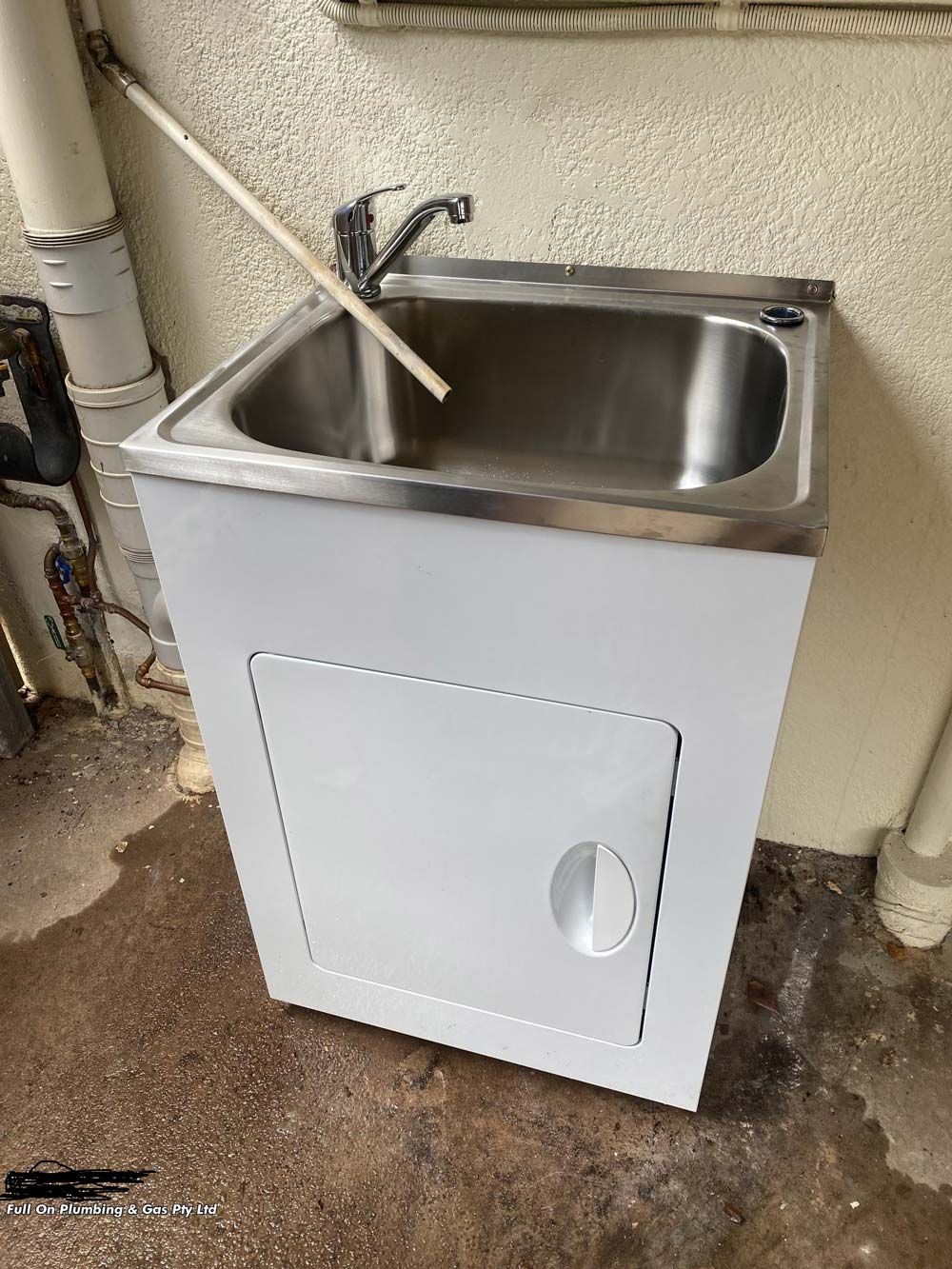 White Utility Sink With Stainless Steel Basin and Cabinet. Set in a Basement — Full On Plumbing & Gas in Winnellie, NT