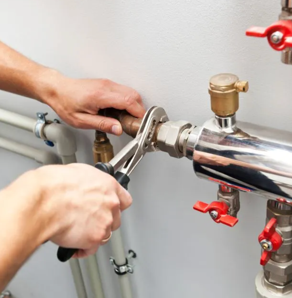 Plumber tightening pipe fittings in a Darwin home