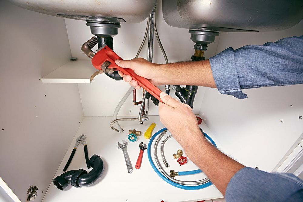 Plumber Working Under a Sink, Using a Wrench — Full On Plumbing & Gas in Winnellie, NT