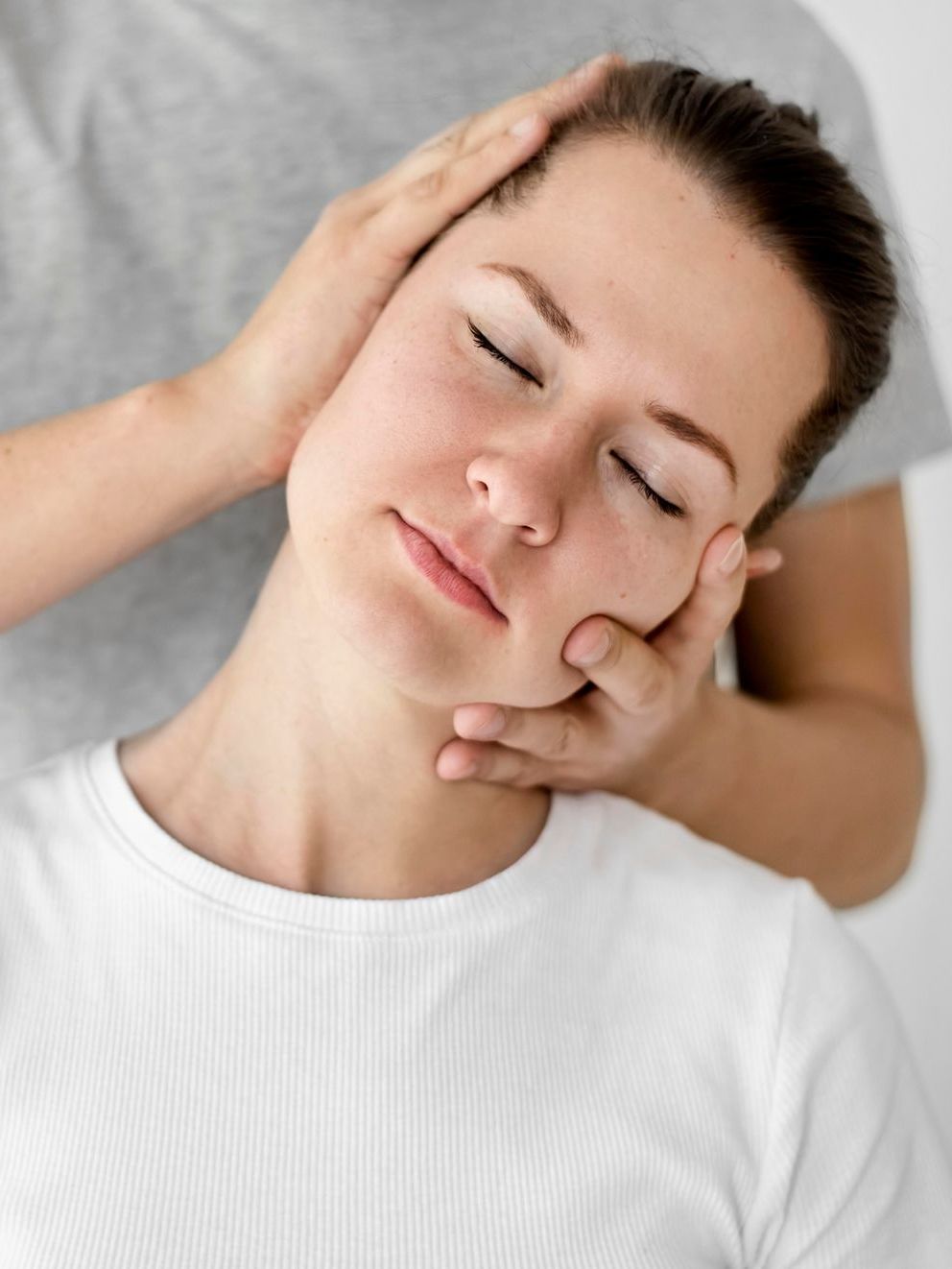 A woman is getting a neck massage from a man.