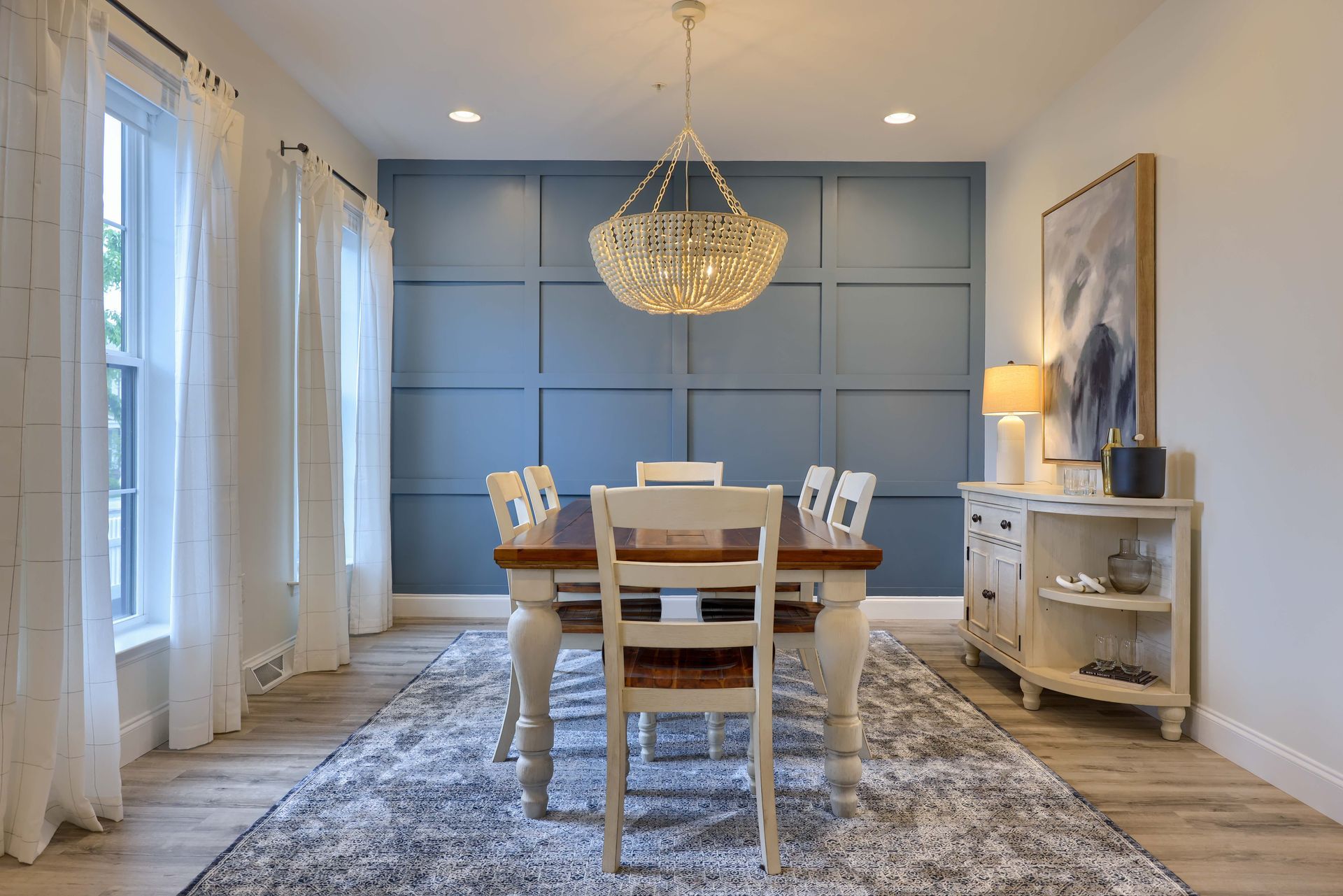 A dining room with a table and chairs and a chandelier.