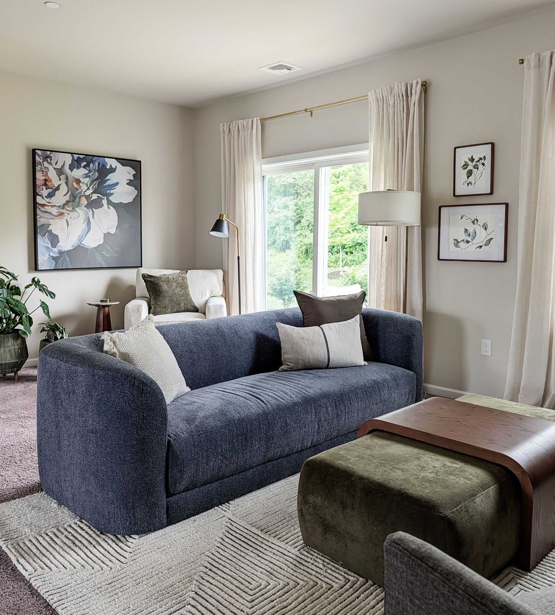 Organic modern living room with blue curved sofa and large green ottoman,
