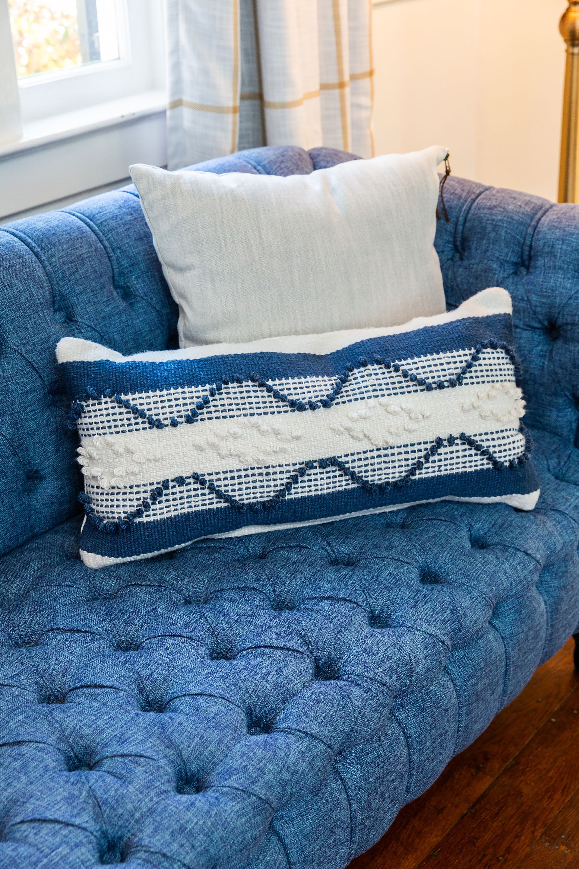 A blue couch with two pillows on it in a living room.