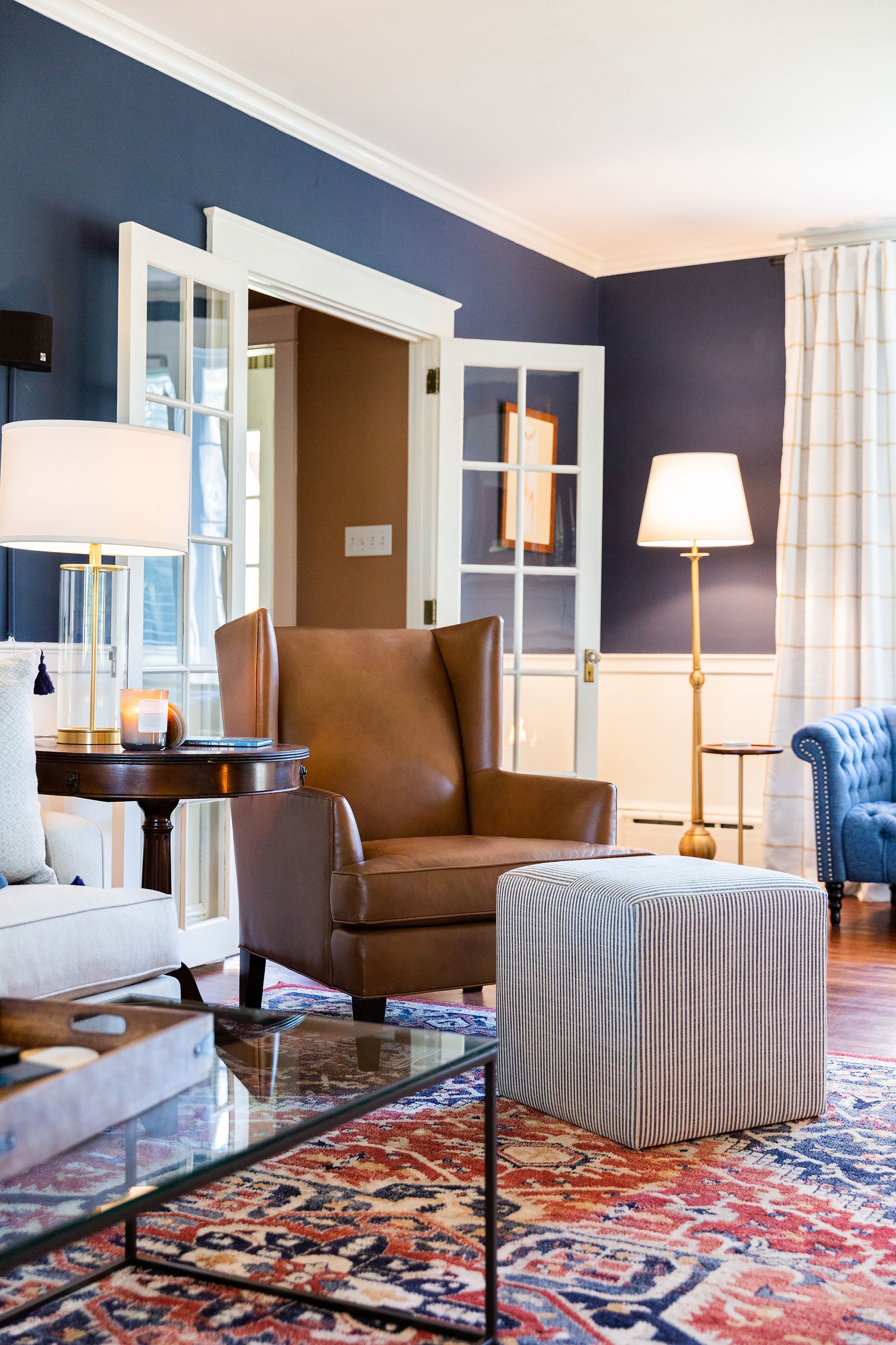 A living room with a couch , chair , coffee table and ottoman.