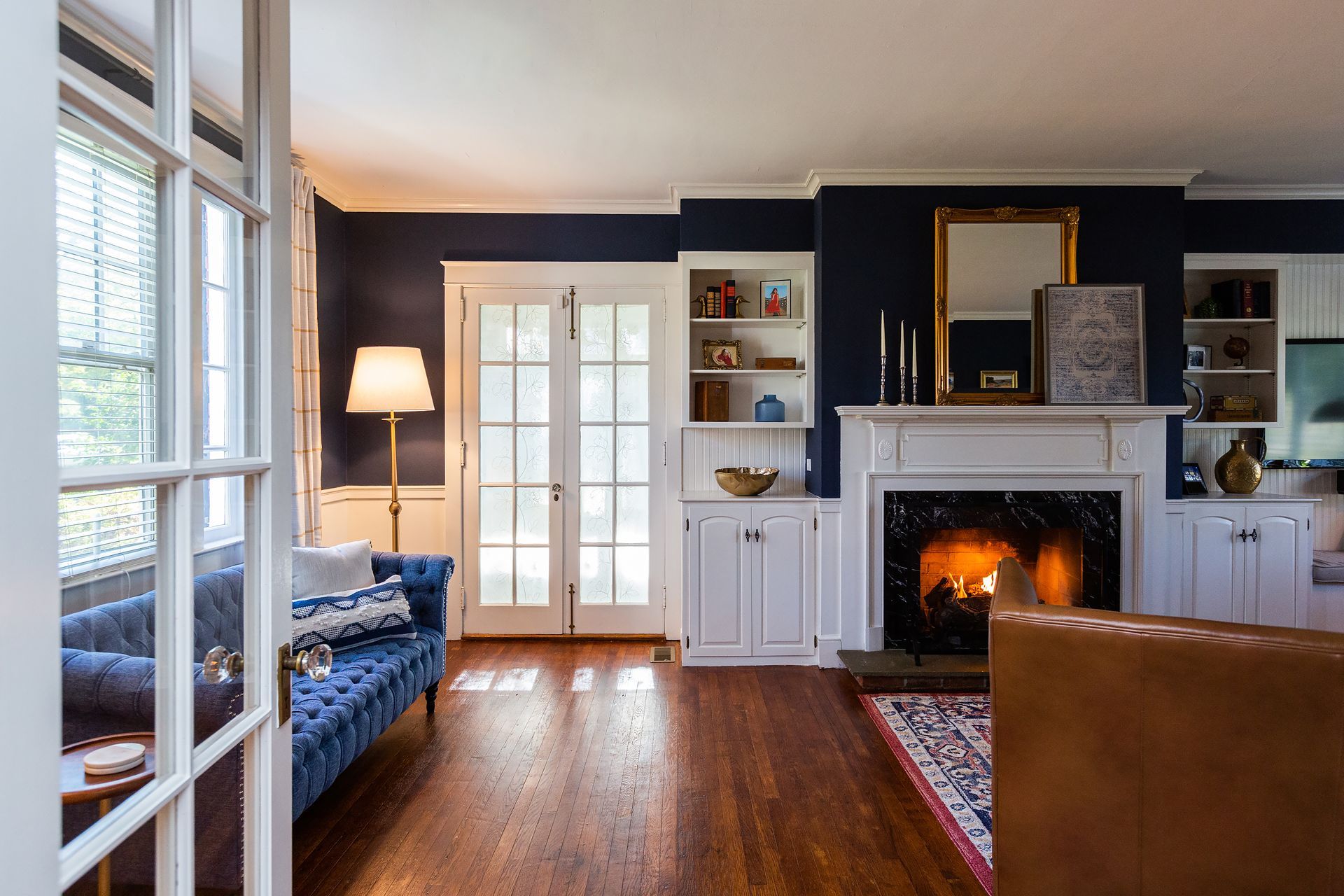 A living room with a fireplace and a blue couch.