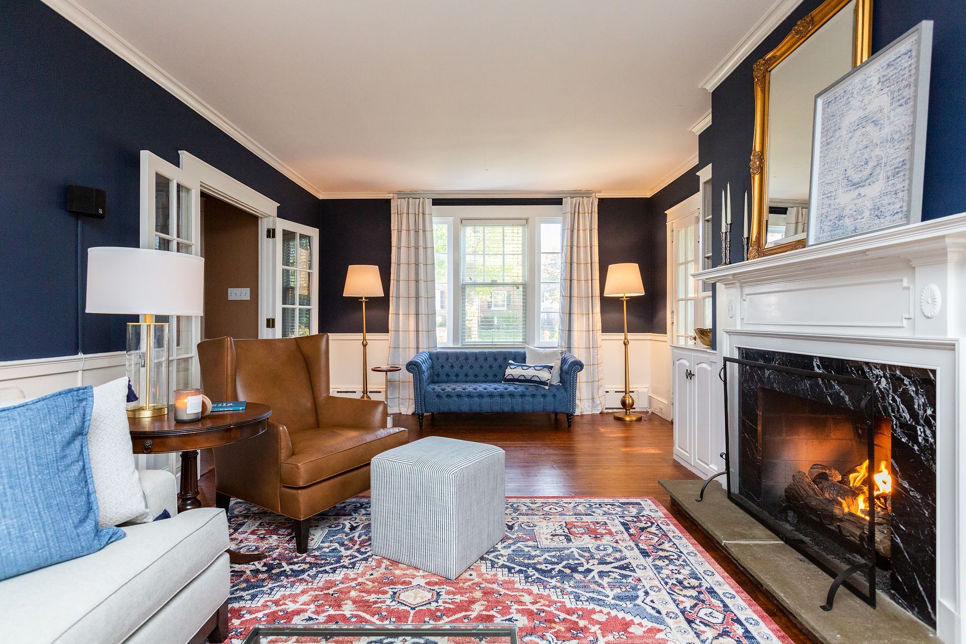 A living room with a fireplace , couch , chair and rug.