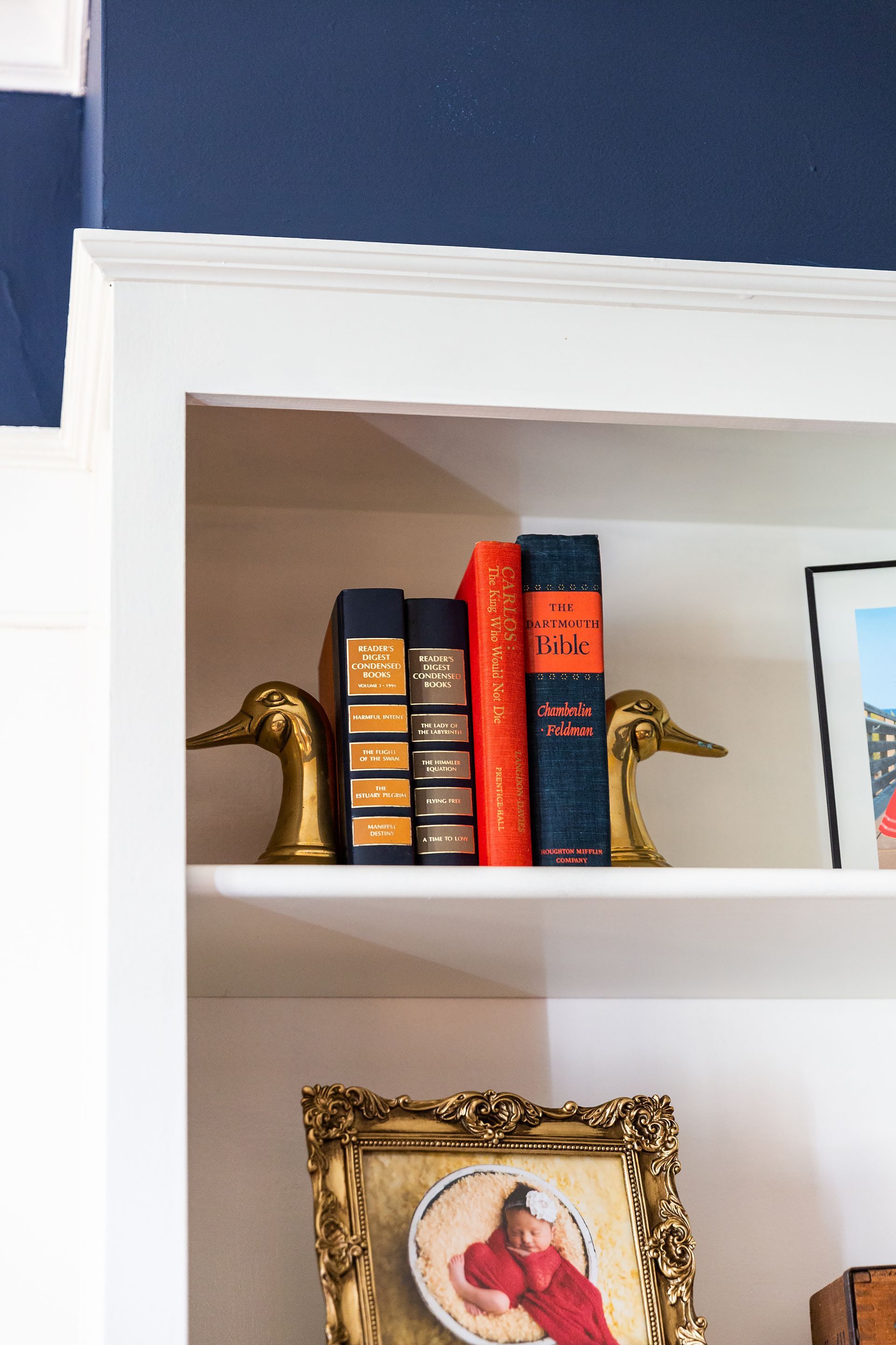A shelf with books and a picture on it