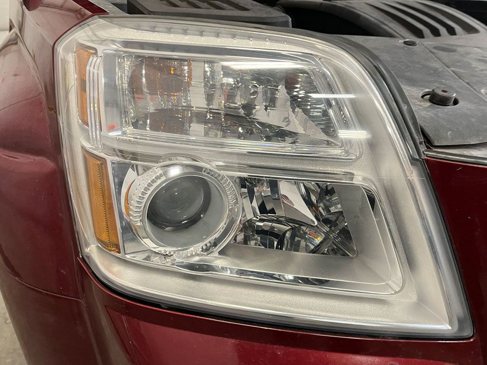 Close-up of a car’s front headlight assembly with chrome trim and amber side marker