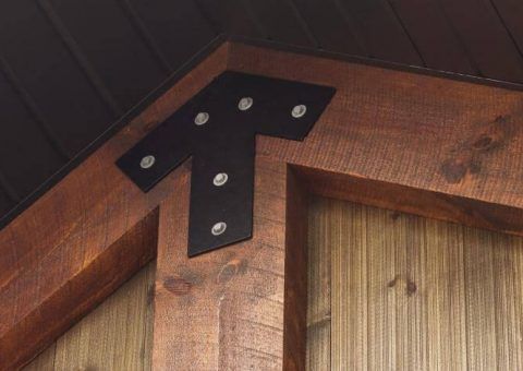 Black metal bracket bolted to corner of wooden beams.