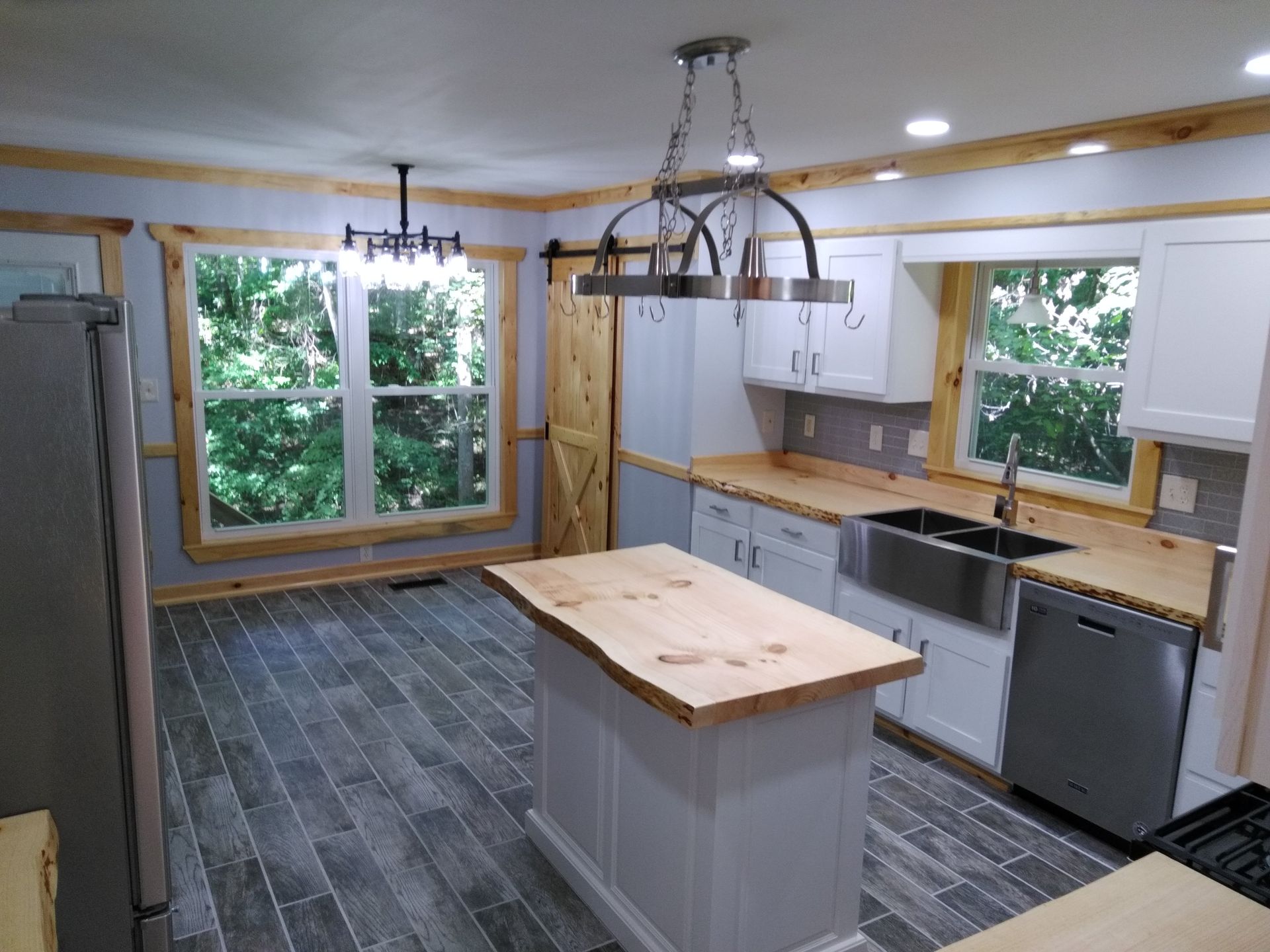 Kitchen with gray tile floor, white cabinets, and wooden countertops.