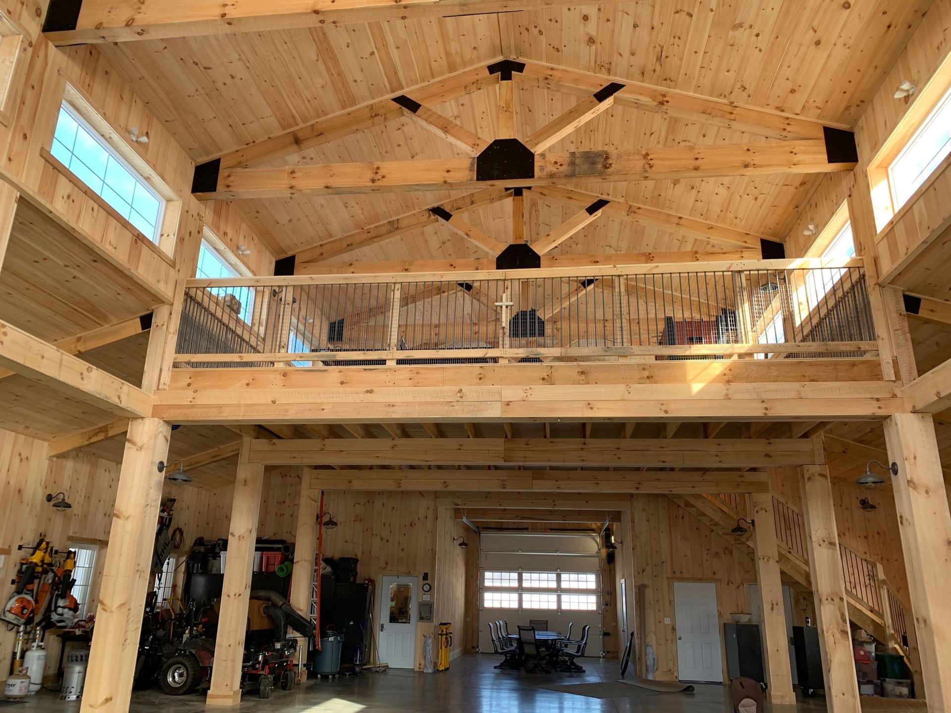 Spacious wooden interior with a second-story balcony and large windows.  Light brown wood throughout.
