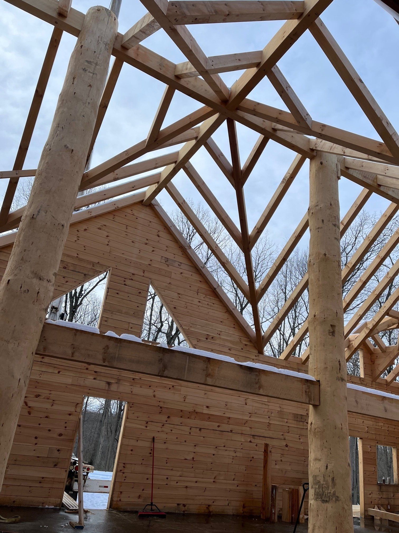 Wooden timber frame construction with open roof structure and supporting pillars.