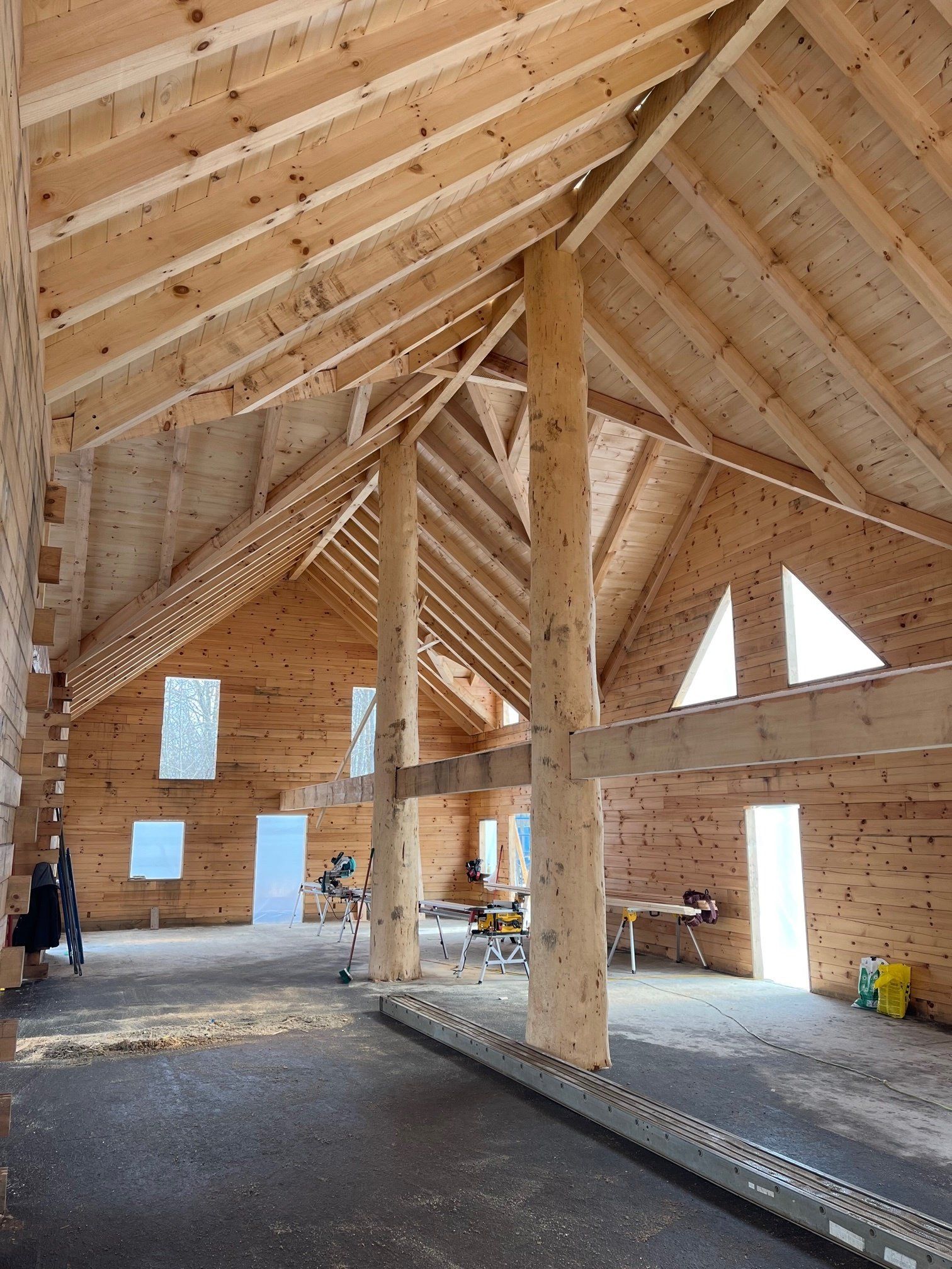 Interior of a building under construction, showing wooden beams, columns, and walls.
