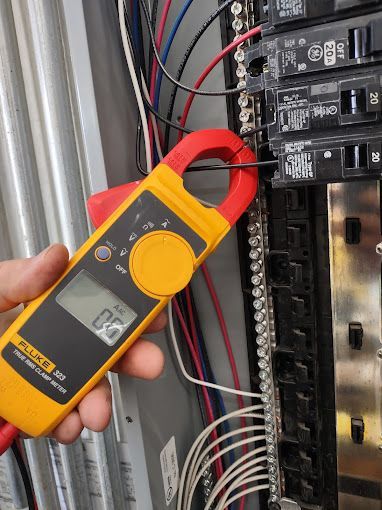 A person is holding a fluke clamp meter in their hand
