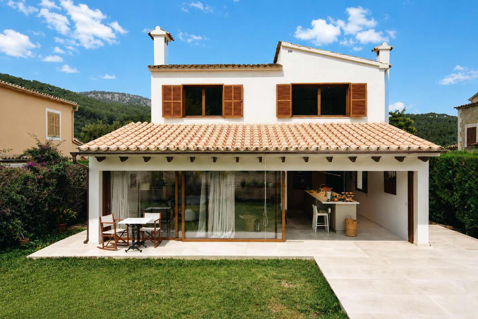 Cocina y sala de estar modernas de planta abierta con isla, mesa de comedor y puertas corredizas de vidrio que dan al patio.