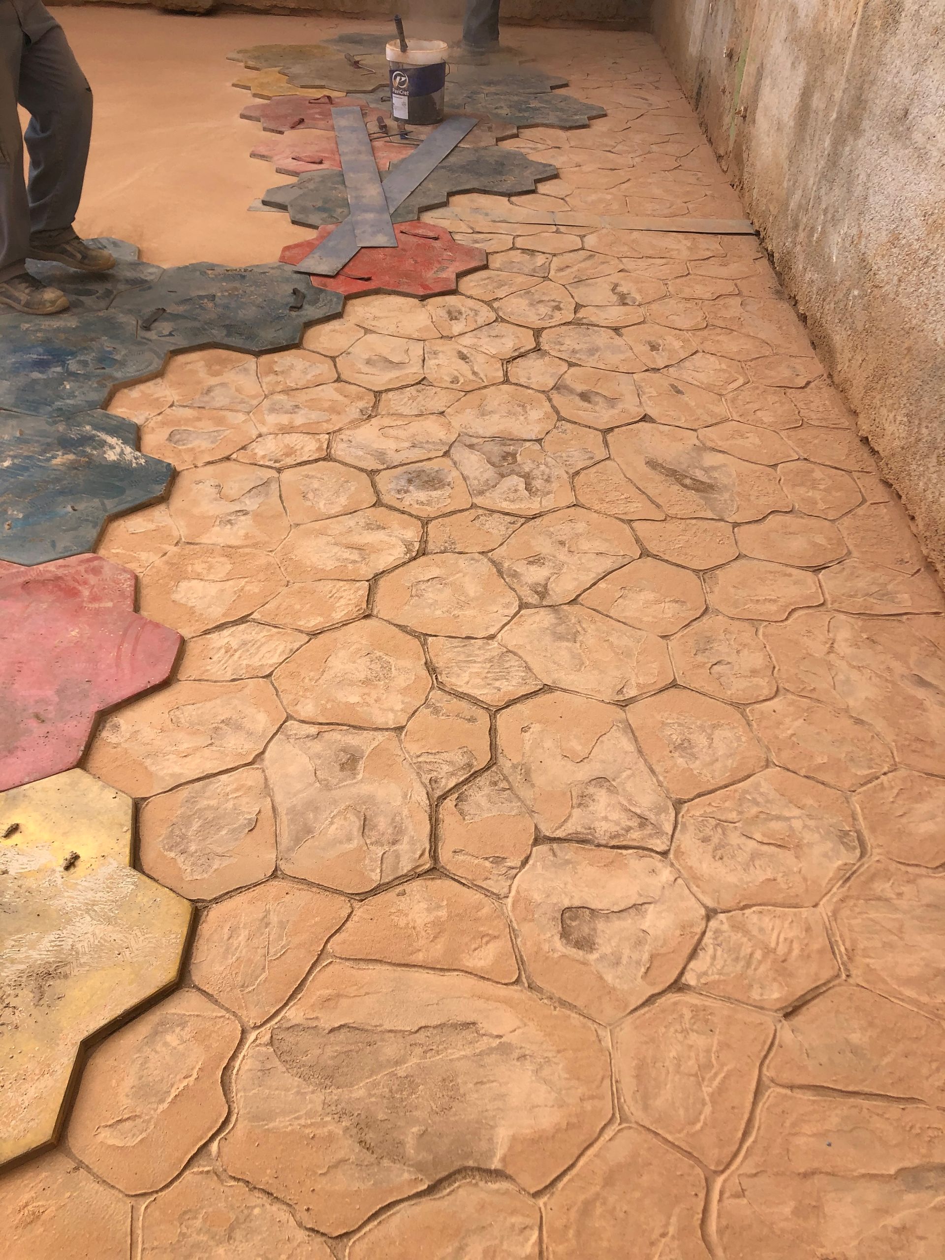Baldosas hexagonales agrietadas de color naranja y gris a lo largo de una pared