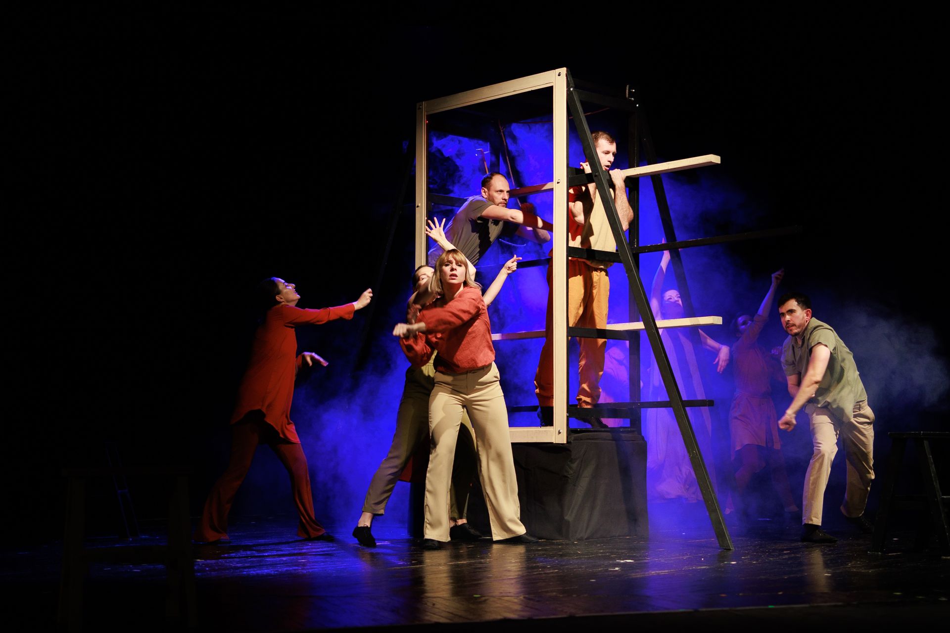 A group of people are standing on a stage in front of a ladder.