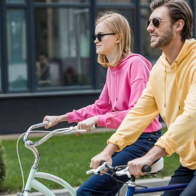 A man and a woman are riding a bike together