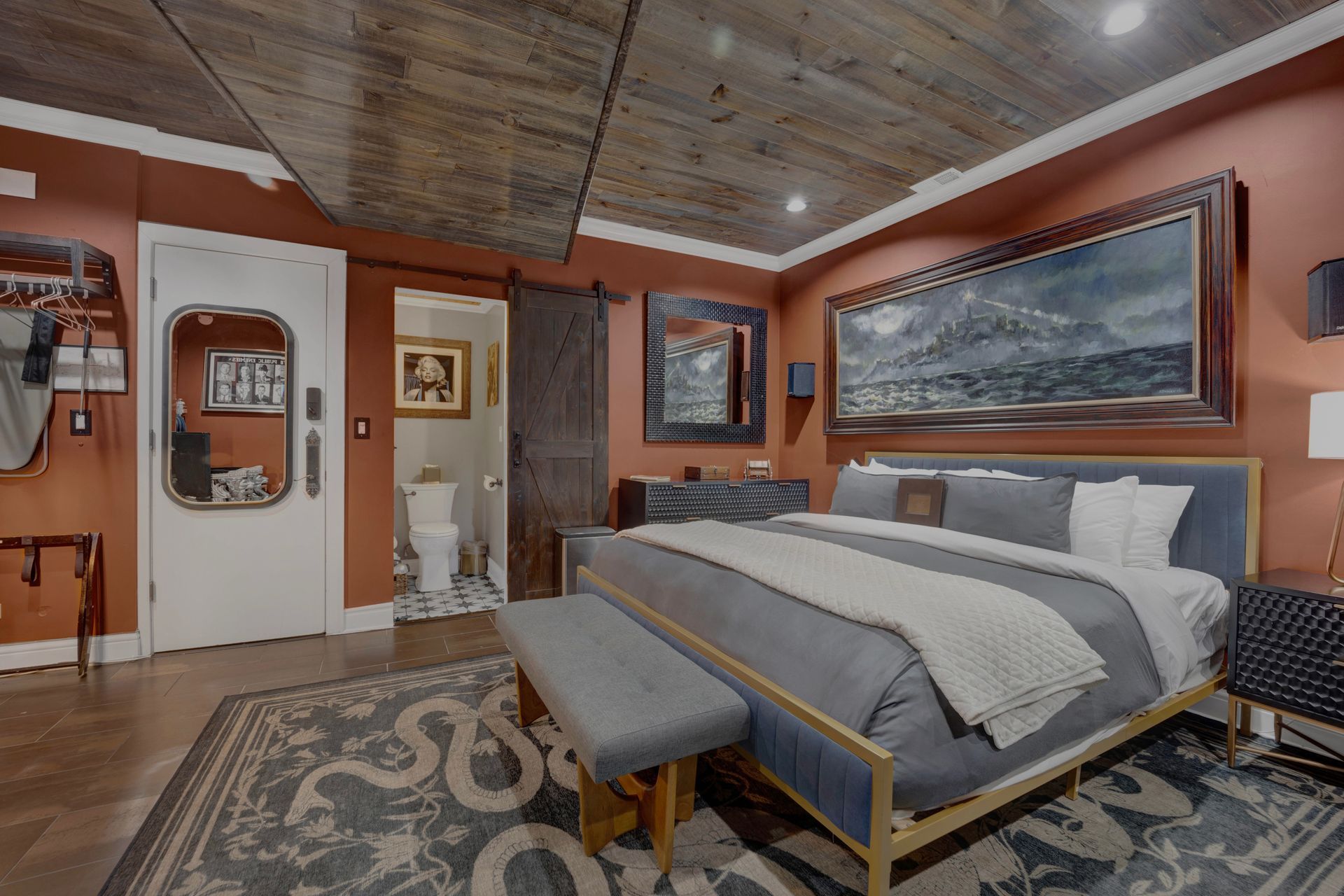 A bedroom with a king size bed and a bench.