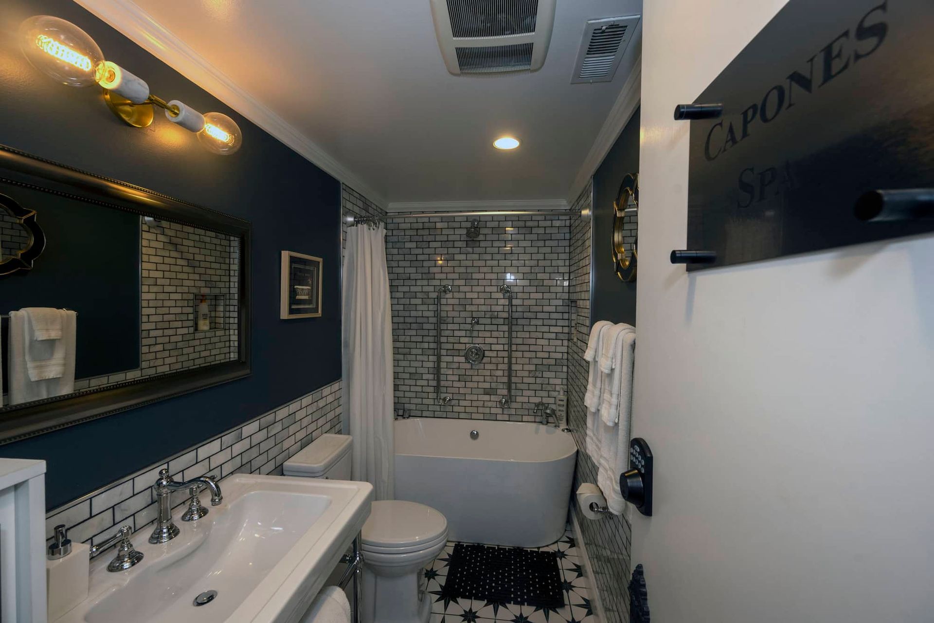 A bathroom with a sink , toilet , tub and mirror.