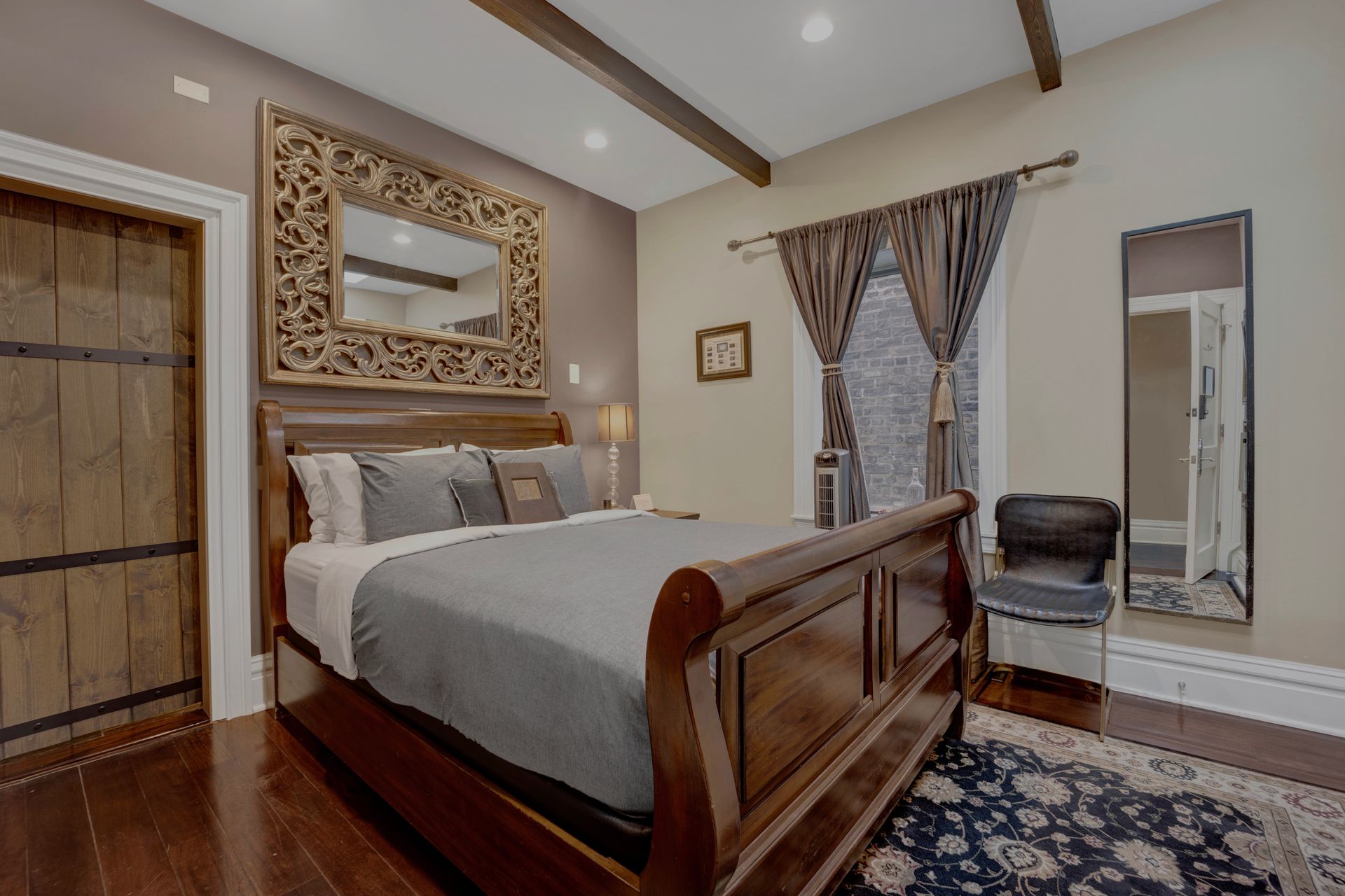 A bedroom with a king size bed and a large mirror on the wall.