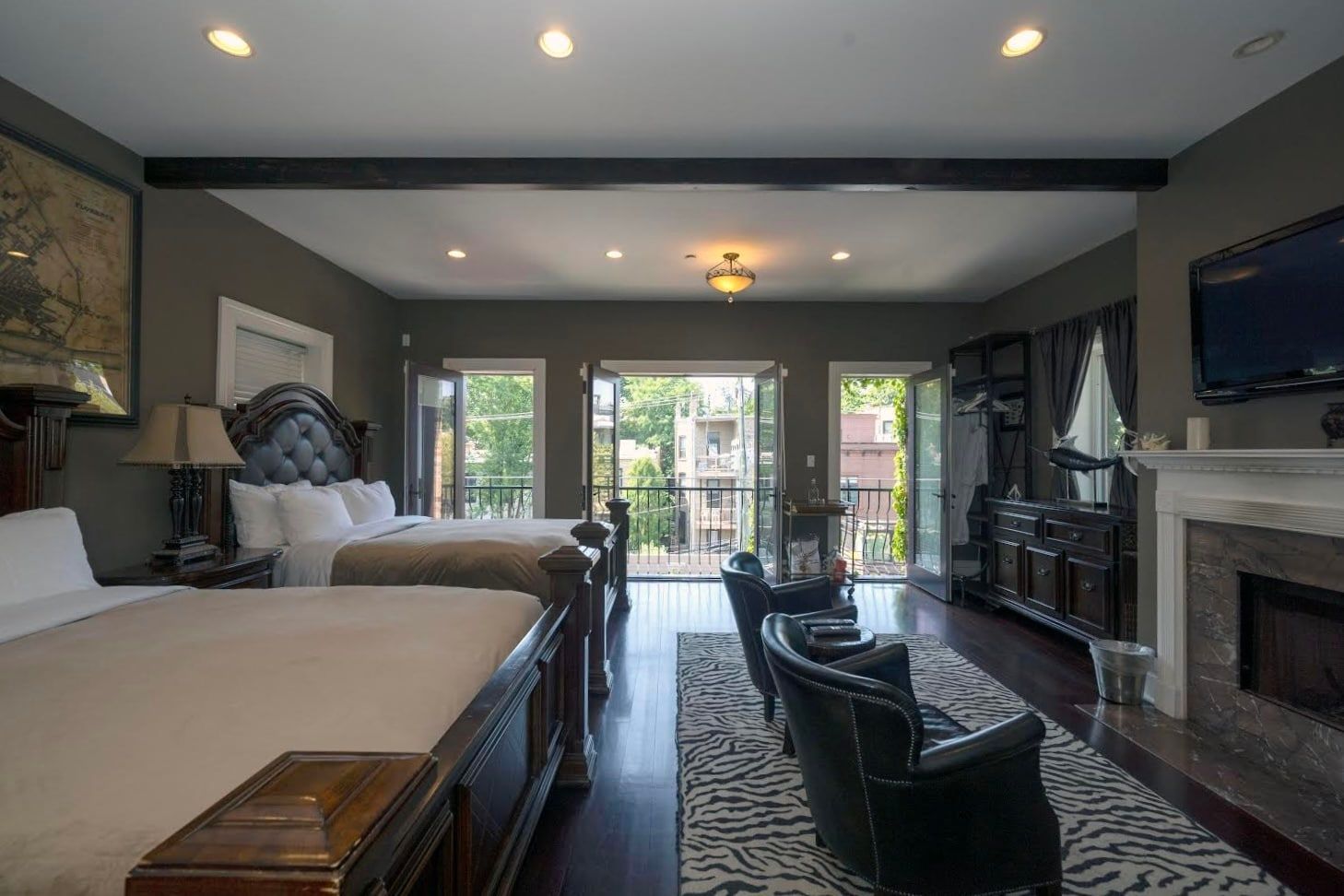 A hotel room with two beds and a fireplace.