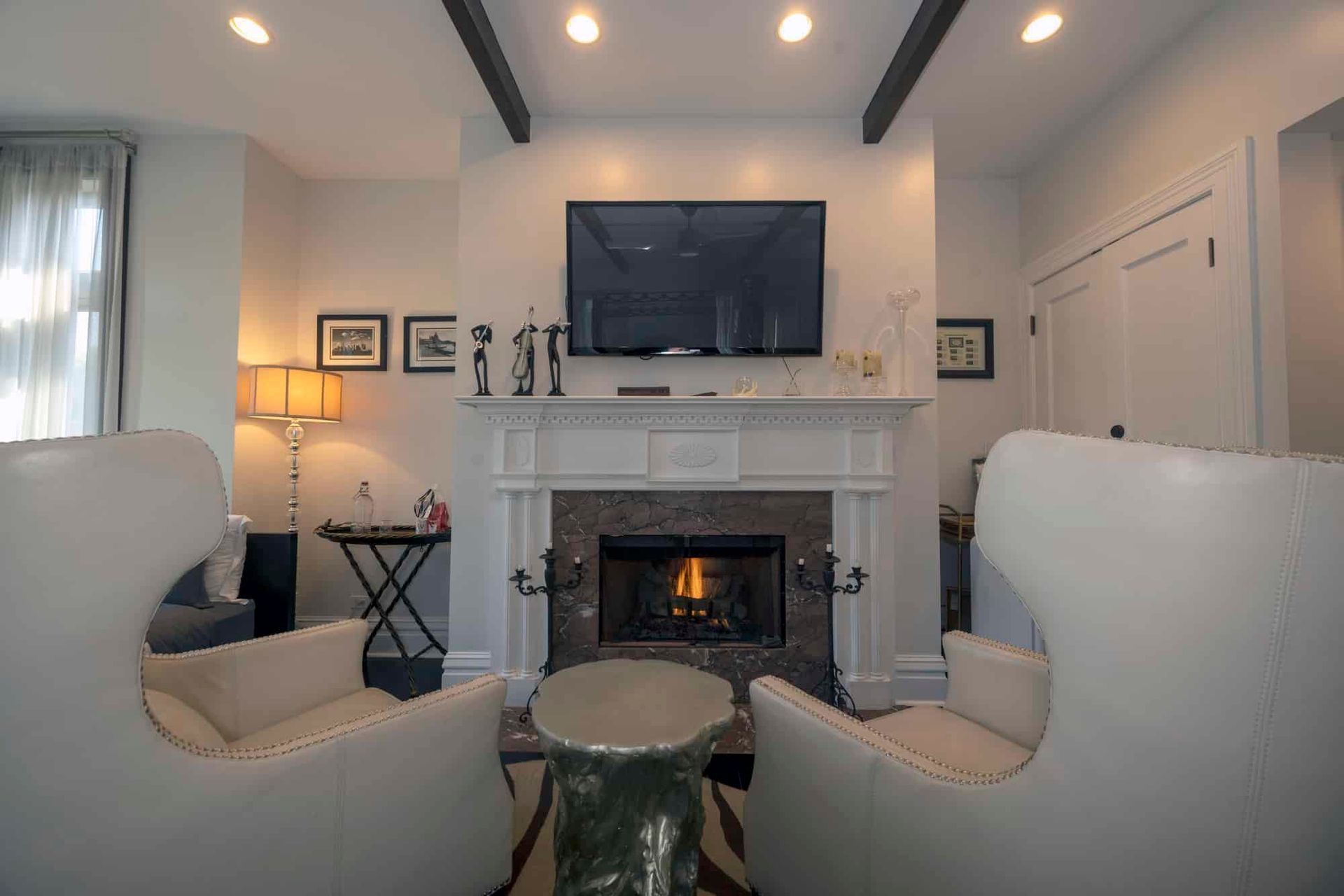 A living room with two chairs , a fireplace and a flat screen tv.
