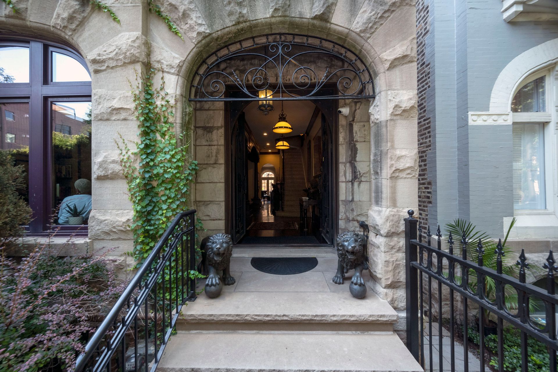 There are two statues of lions in front of the entrance of a building.
