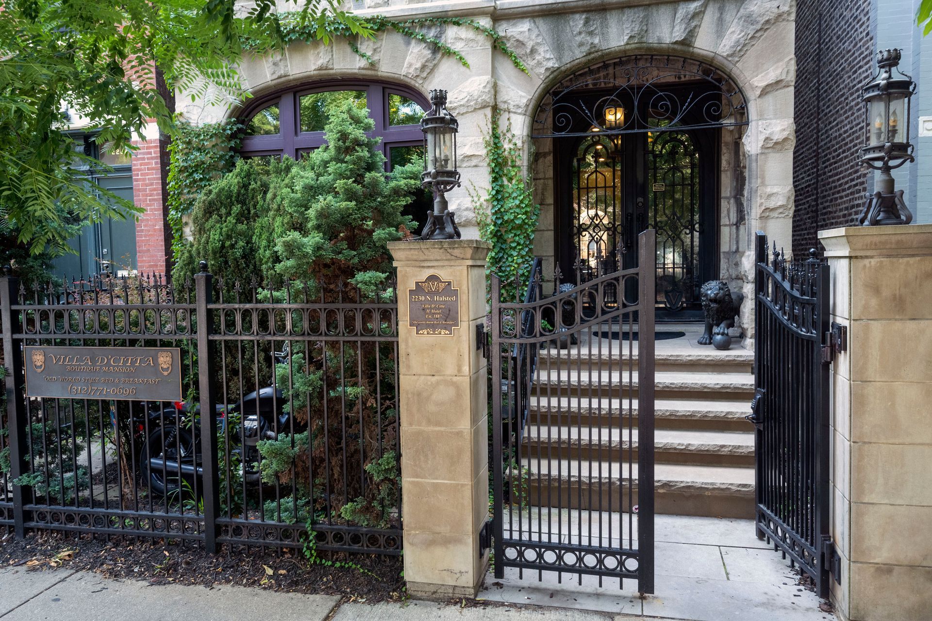 The front of a house with a wrought iron gate and stairs leading to it.