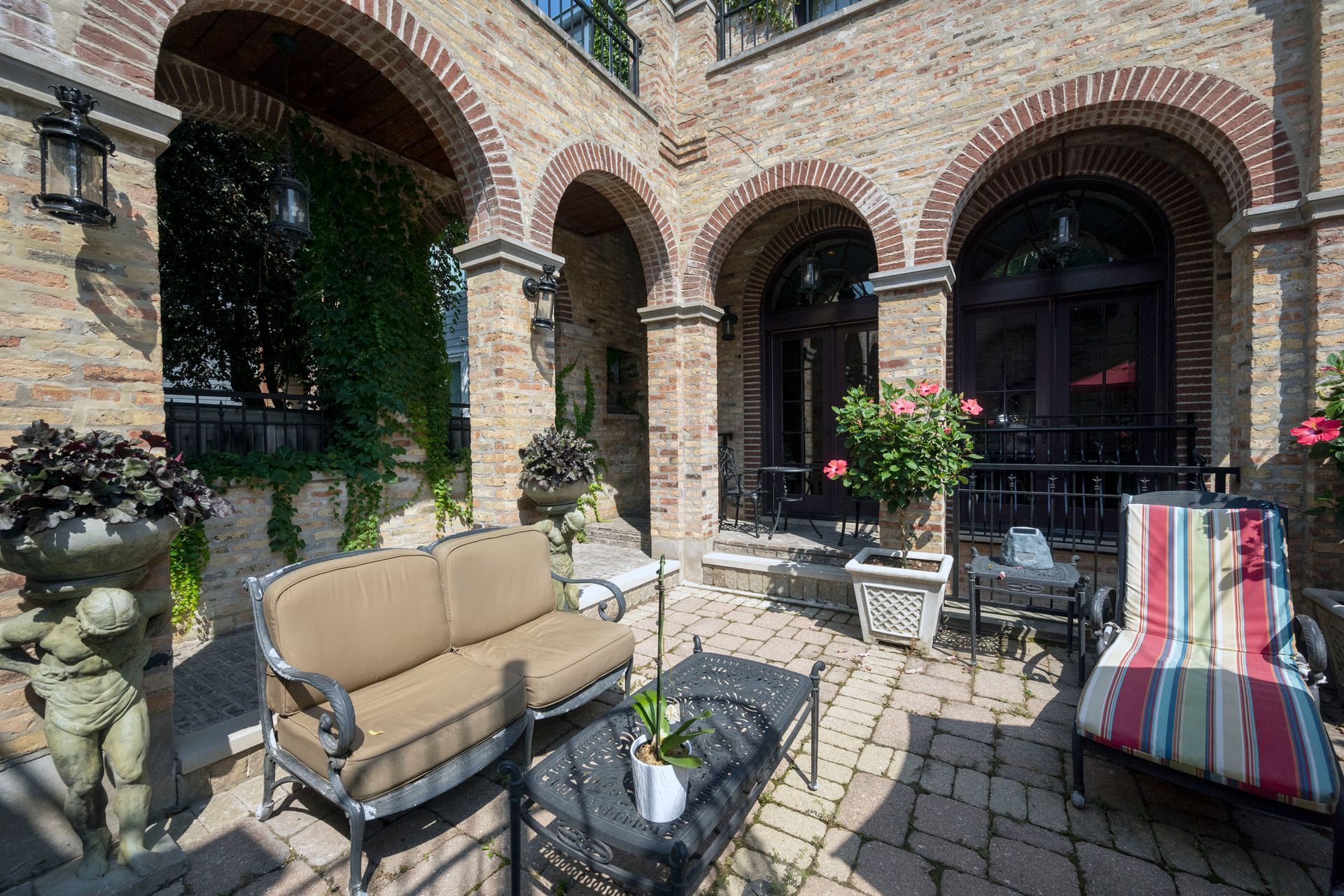 A patio with a couch , chairs , and a table.