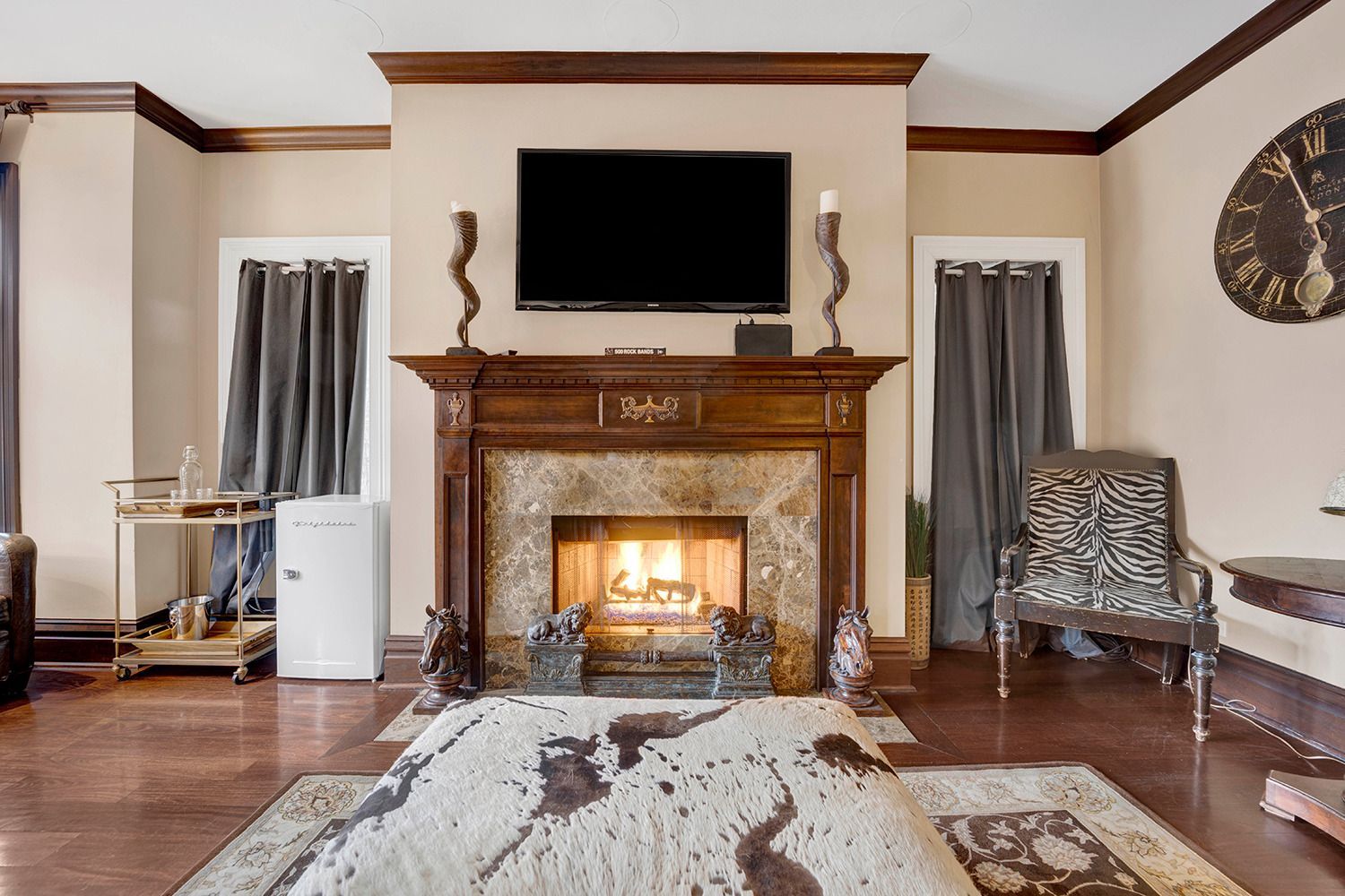 A living room with a fireplace and a flat screen tv on the wall.