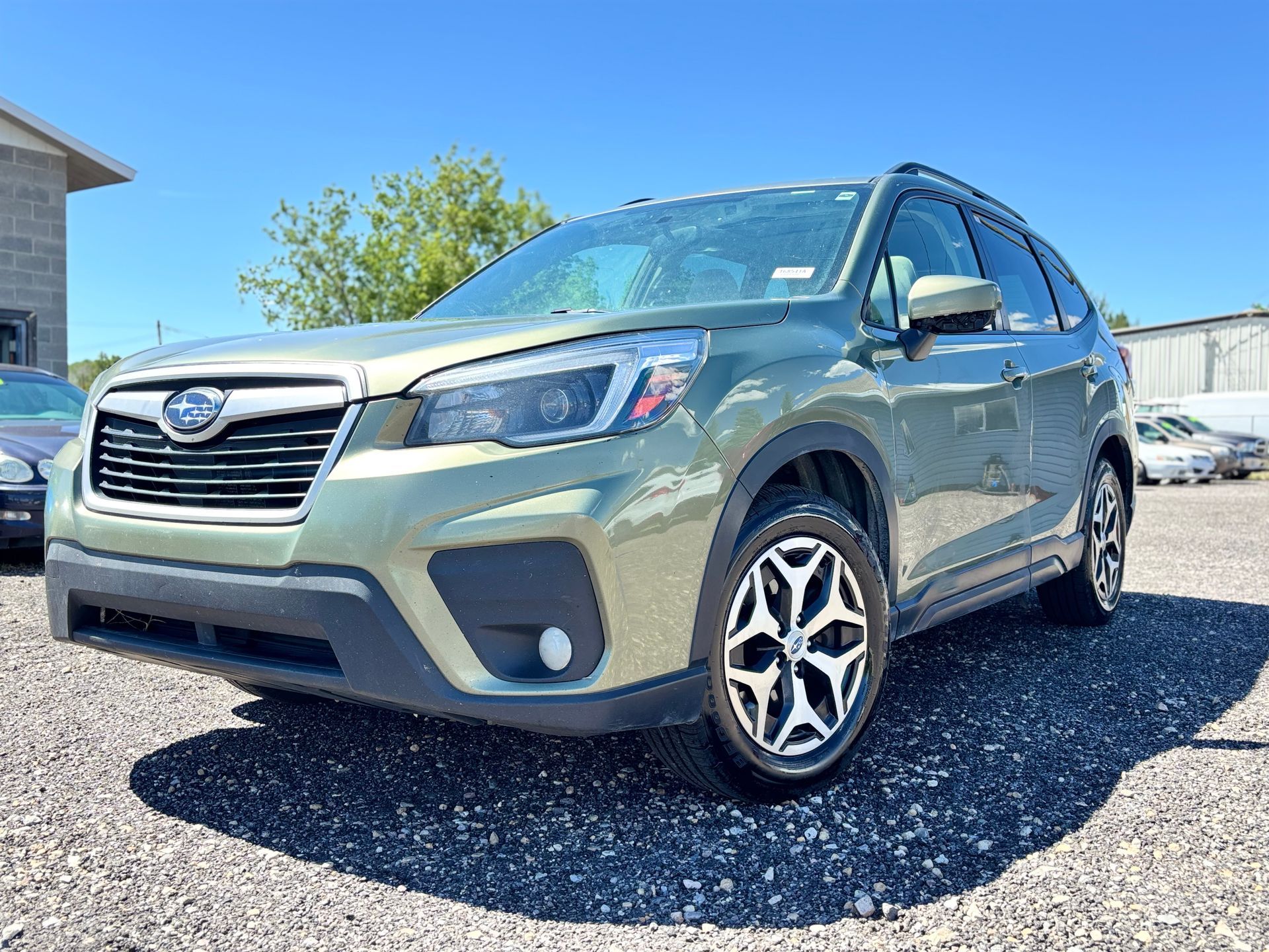 Silver Subaru SUV parked on gravel in a sunny lot
