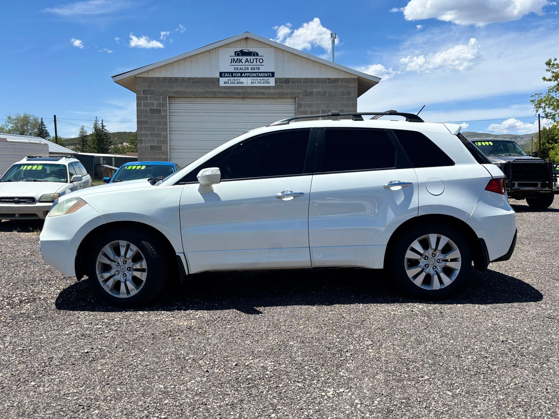 White SUV parked in front of a building under a bright blue sky