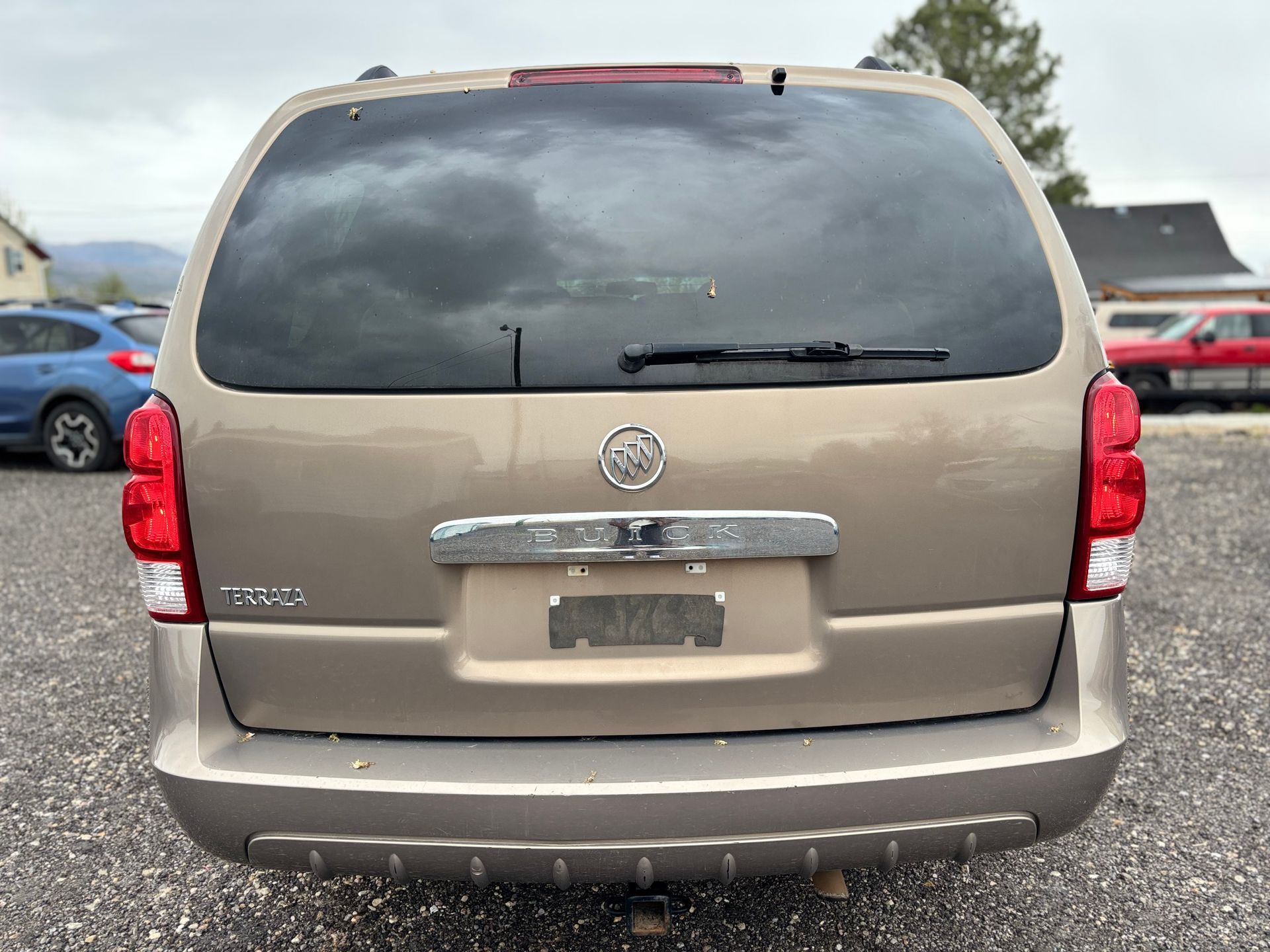 Rear view of a beige Toyota Sienna minivan in a parking lot