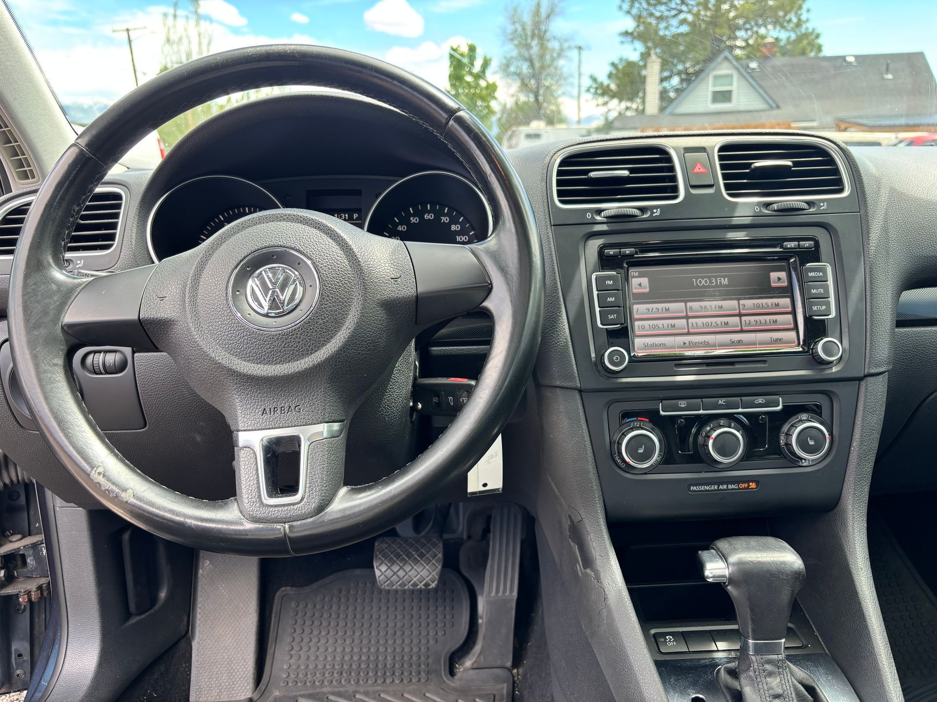 Car interior with steering wheel, dashboard, center console, and manual gear shift