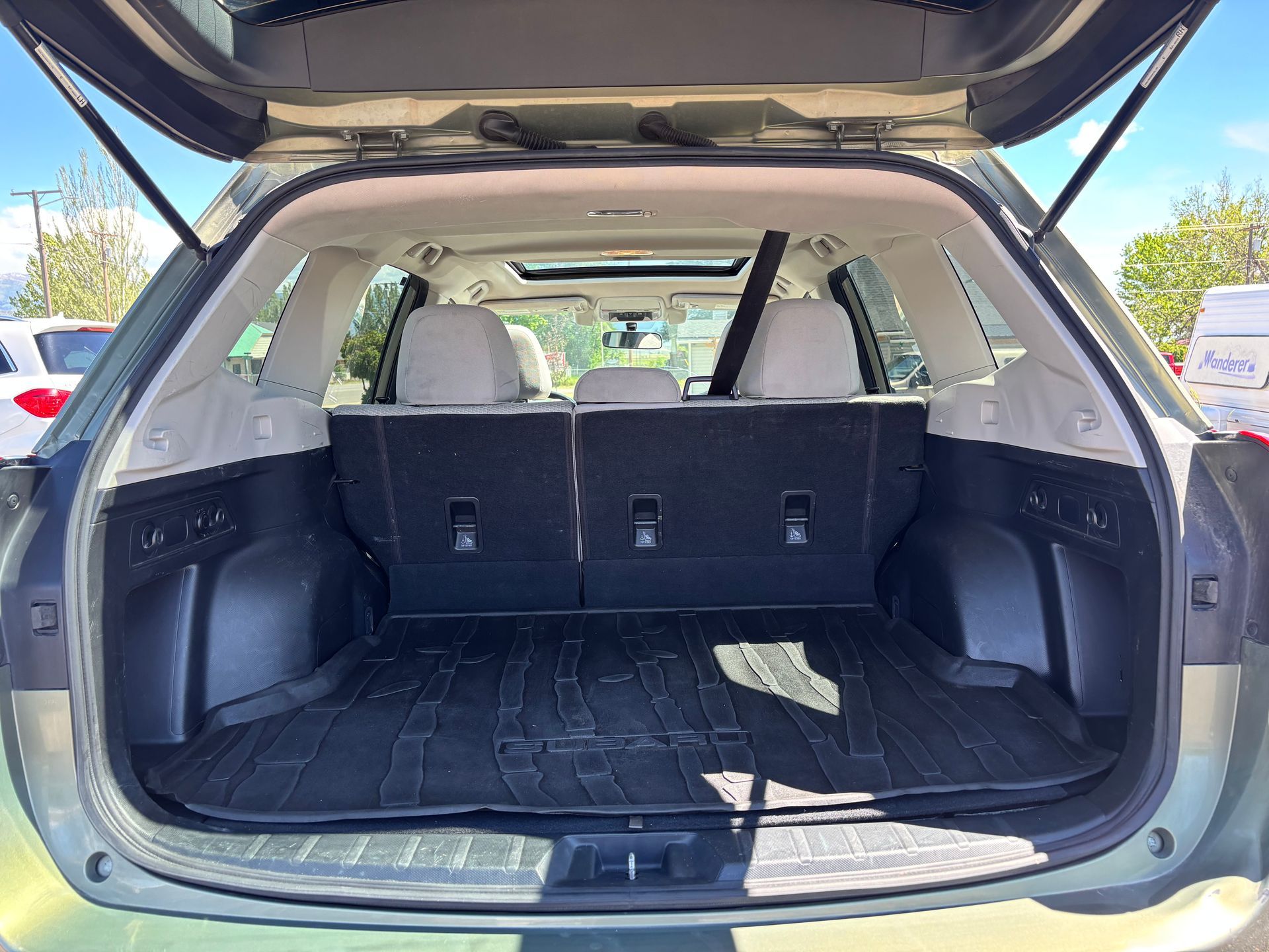 Open SUV cargo area with rear seats folded down and black interior mats.