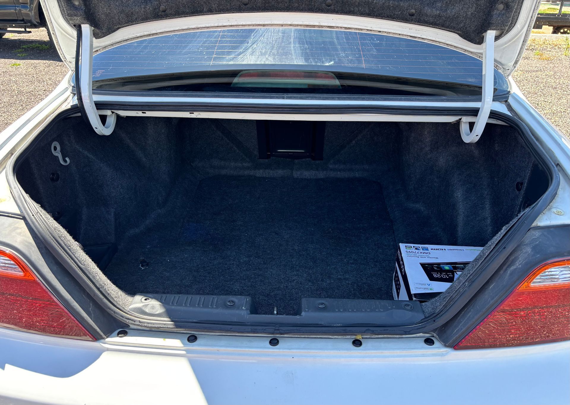 Open car trunk with empty black interior and gray exterior visible