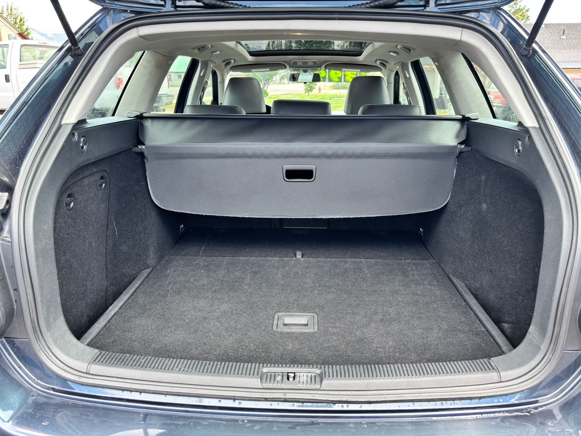 Open SUV cargo area with black carpeted trunk and a raised rear seatback panel