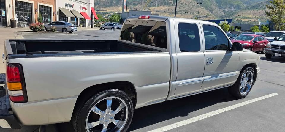 Silver pickup truck parked in a lot with mountains in the background