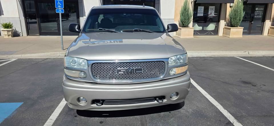 Front view of a silver pickup truck parked in a marked parking space outside a building.